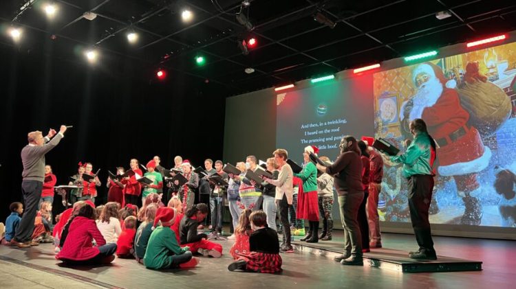 Welborn Young conducts members of Bel Canto Company at The Night Before Christmas as children from the audience listen onstage