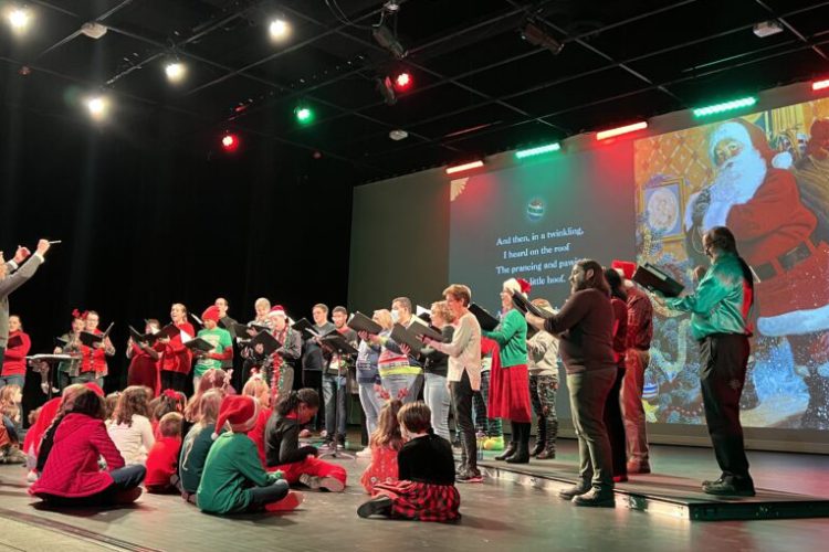 Welborn Young conducts members of Bel Canto Company at The Night Before Christmas as children from the audience listen onstage