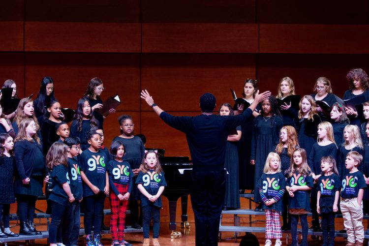 LJ Martin conducts Greensboro Youth Chorus Music Explorers, Apprentice Choir, and Concert choir on stage at Tew Recital Hall